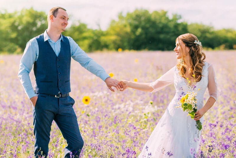 A couple in a field collecting flowers