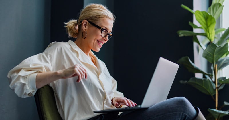 A woman reading insights articles on her laptop