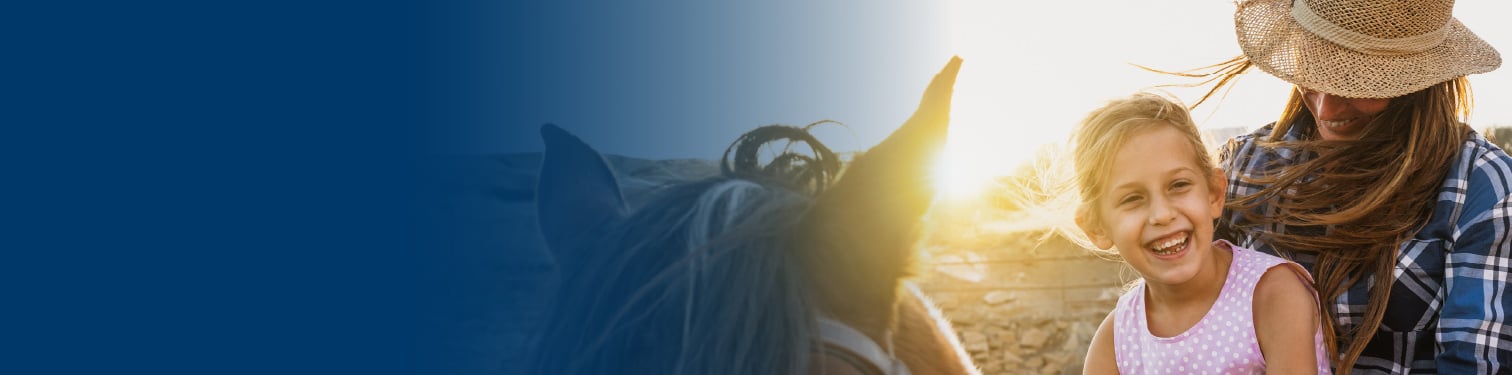 A mother and daughter out riding on her horse