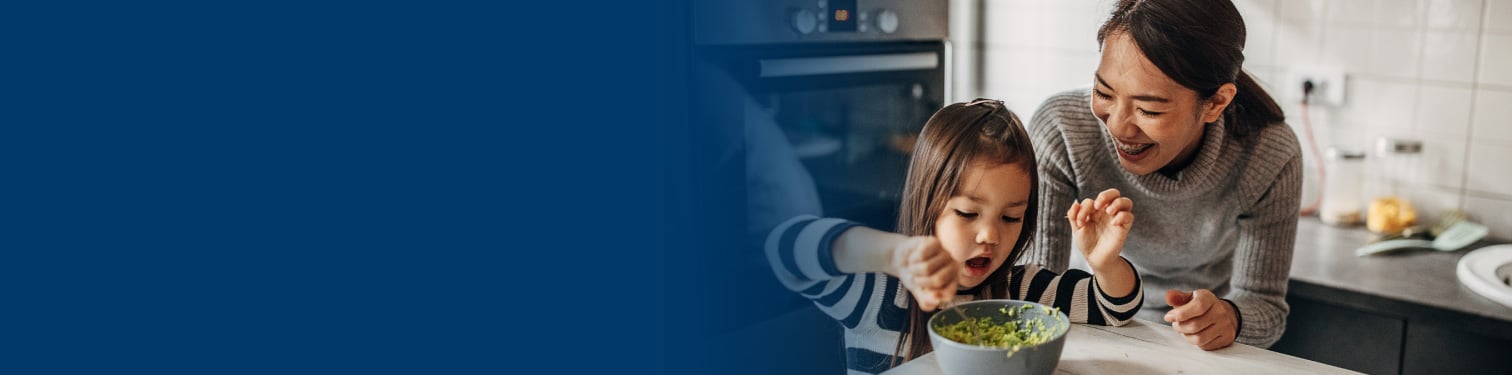 A mom and daughter eating in their kitchen