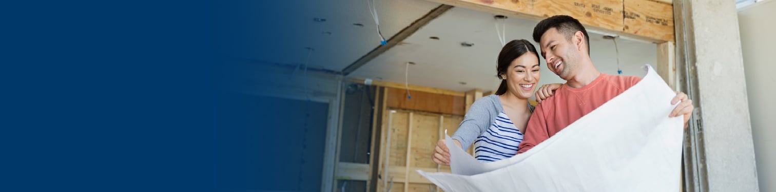 A couple looking at plans for their home renovation project