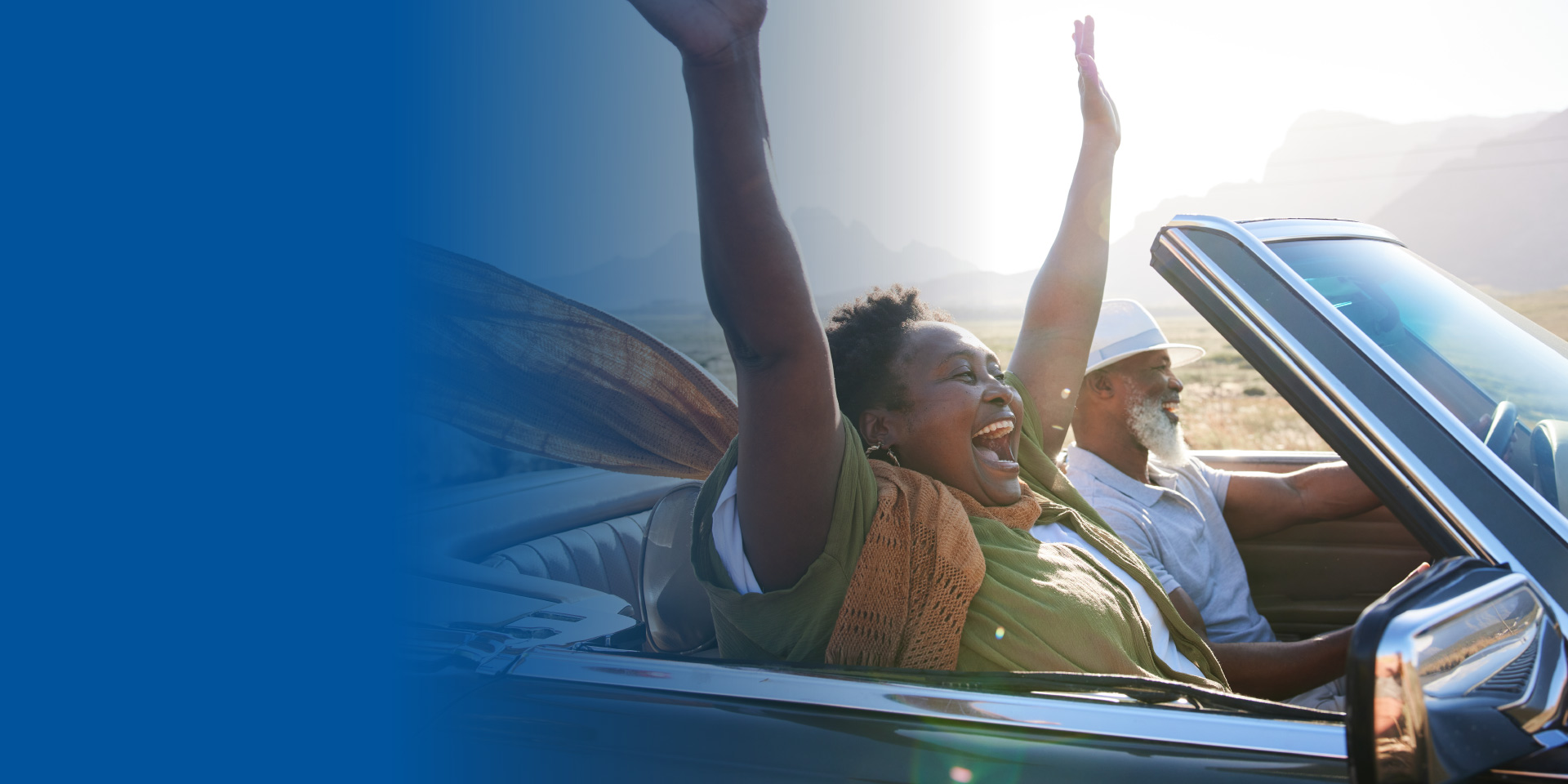 Couple riding in a convertible with the top down